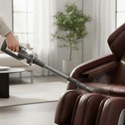 A person carefully vacuuming a brown leather massage chair with a soft brush attachment